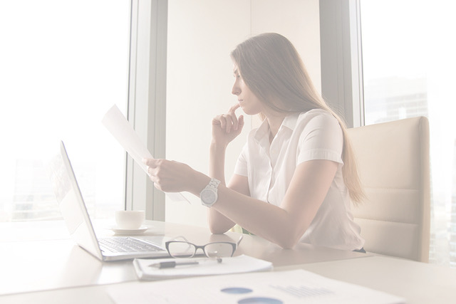Pensive businesswoman reading document in office